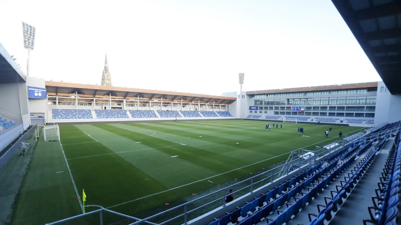 View of stadium with players training on pitch View of stadium with players training on pitch