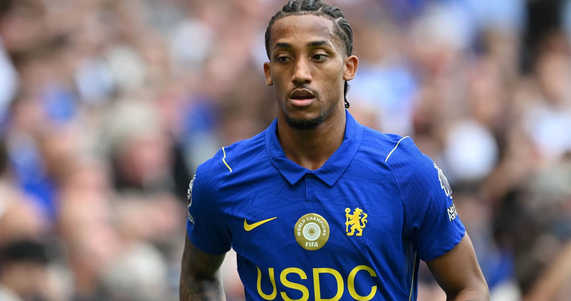 Player wearing blue Chelsea jersey on the field Player wearing blue Chelsea jersey on the field