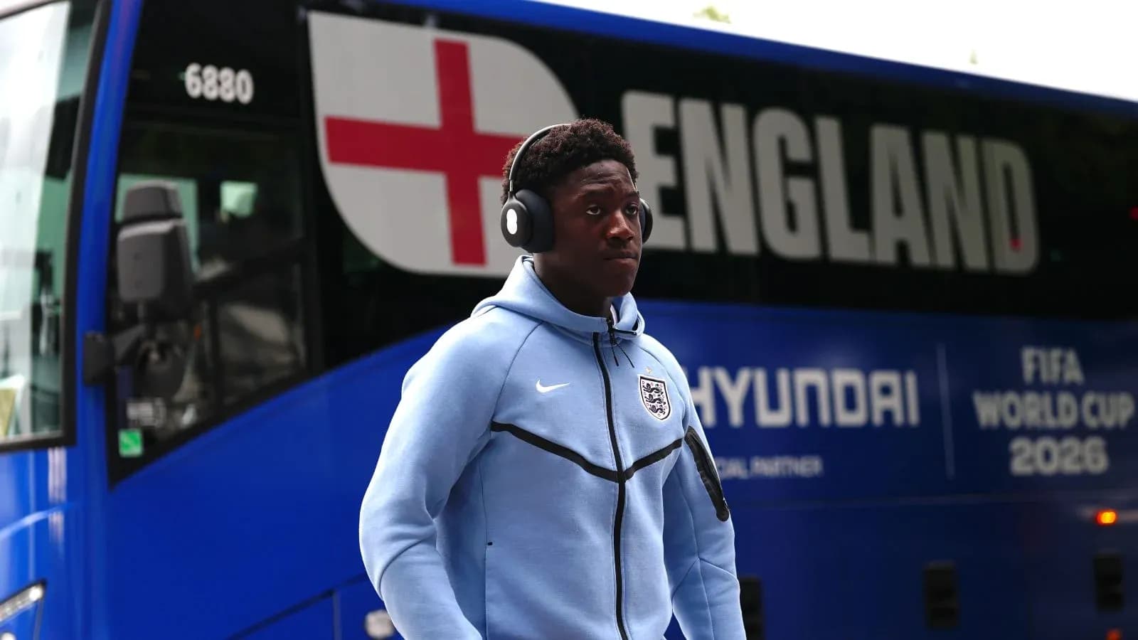 Player wearing headphones walking past England team bus Player wearing headphones walking past England team bus