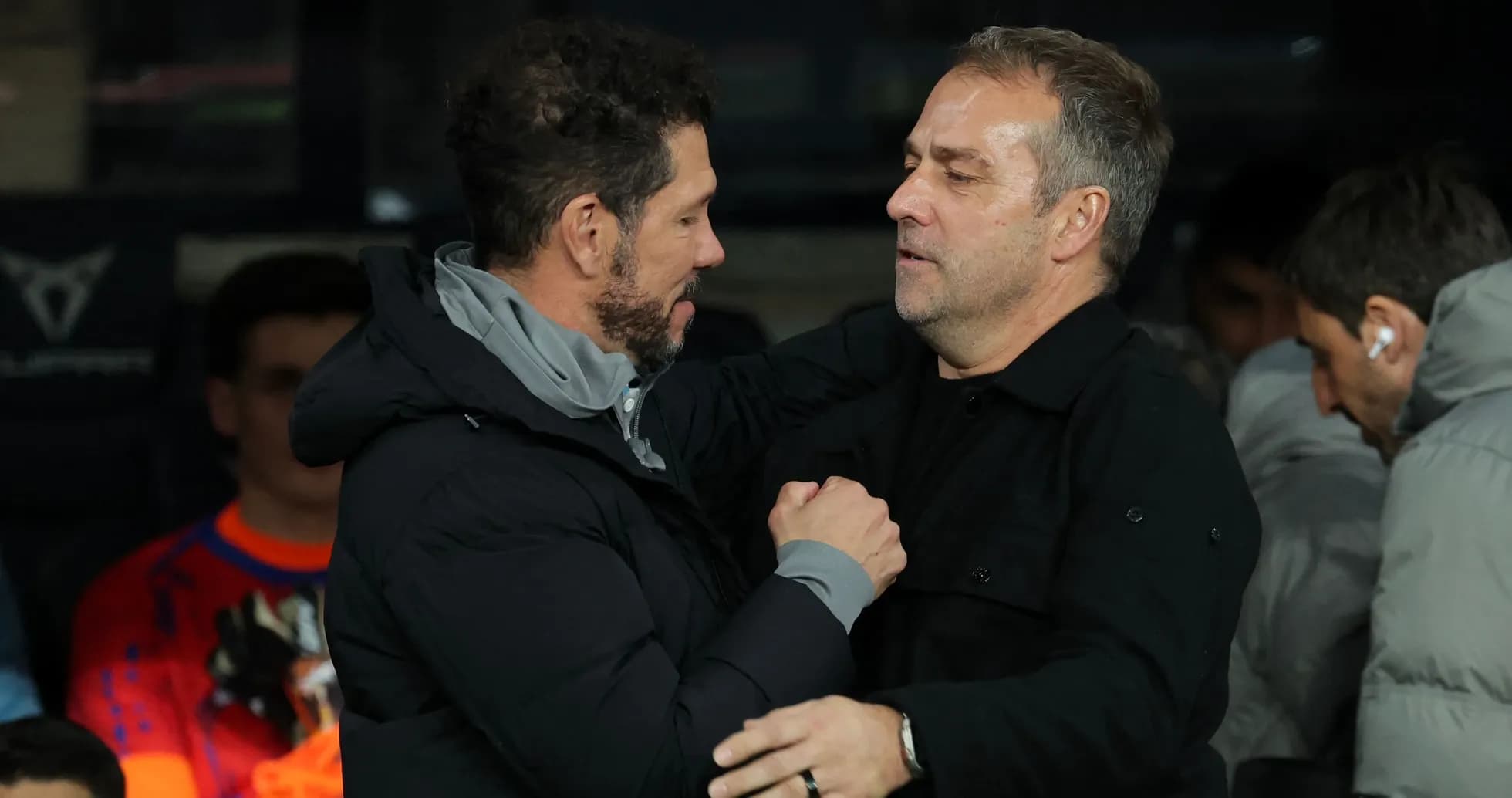 Two coaches sharing a handshake on the sidelines Two coaches sharing a handshake on the sidelines