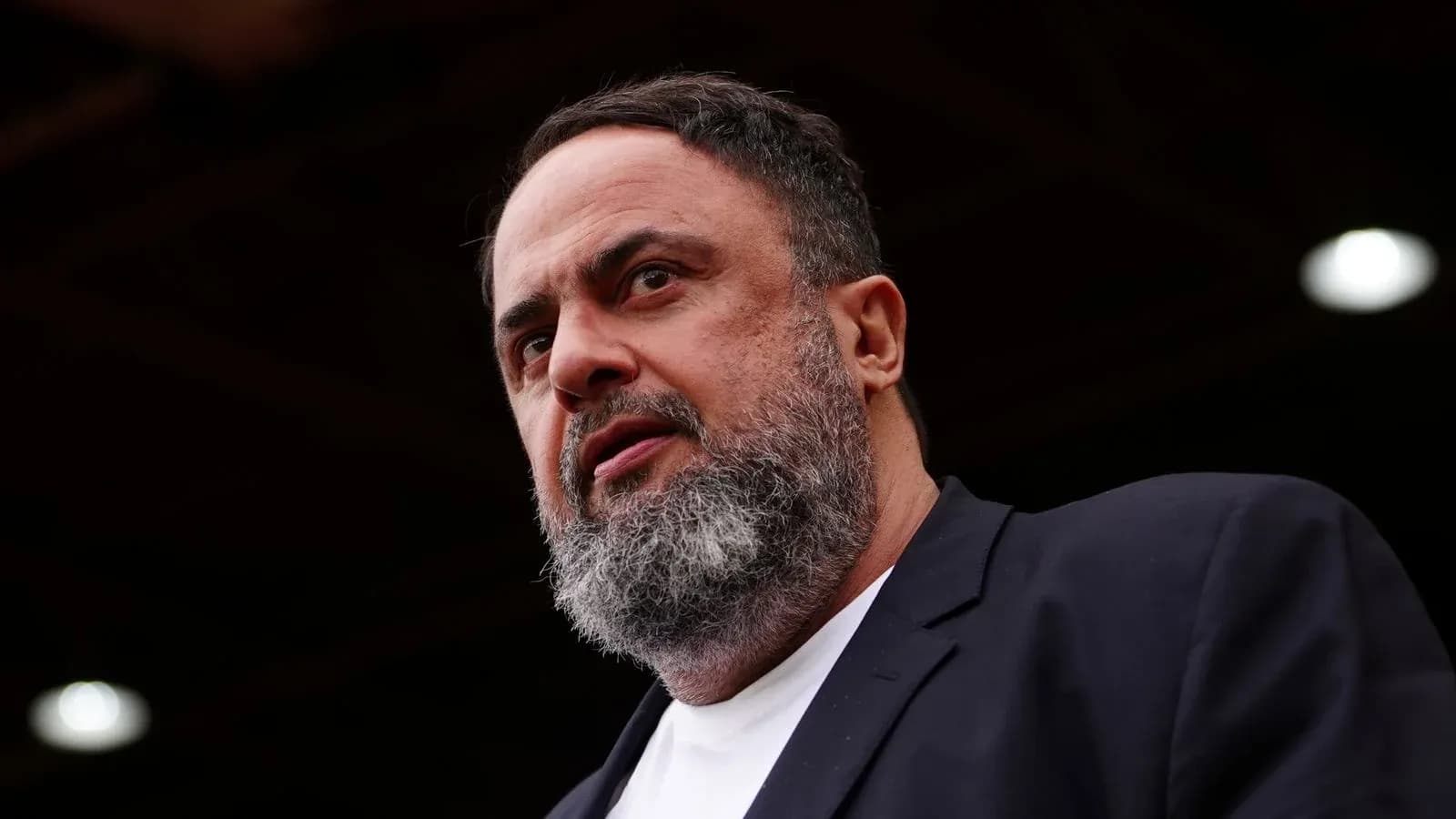 Man speaking at an event with serious expression Man speaking at an event with serious expression