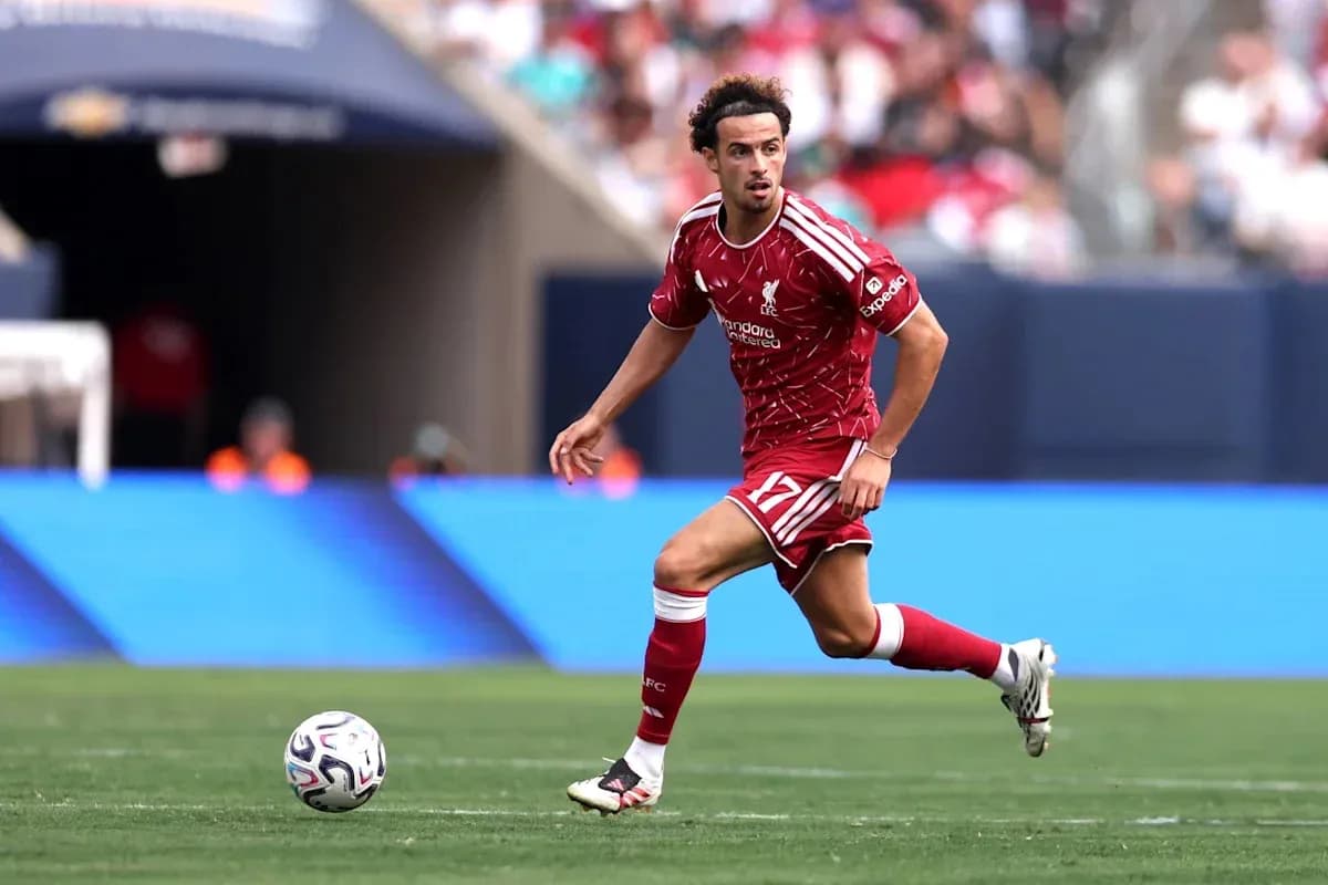 Player in red Liverpool kit running with the ball Player in red Liverpool kit running with the ball