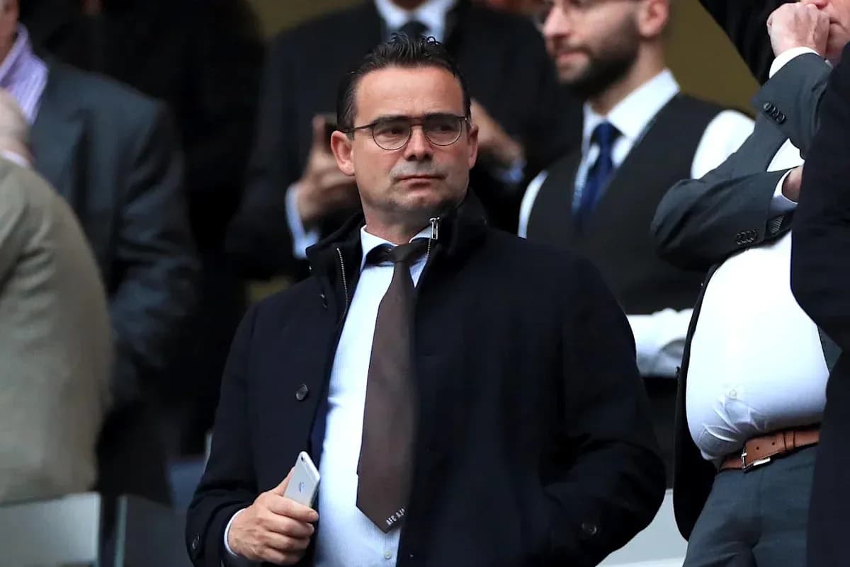 Man in suit observing from the stands at a match Man in suit observing from the stands at a match