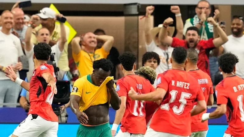 Players celebrating a goal with fans cheering Players celebrating a goal with fans cheering