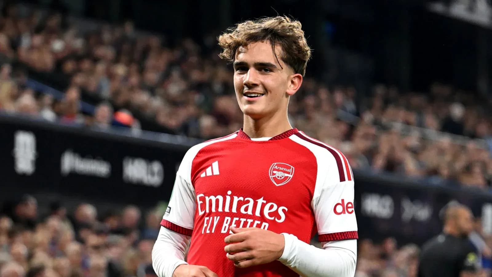Player in Arsenal kit smiling on the field Player in Arsenal kit smiling on the field
