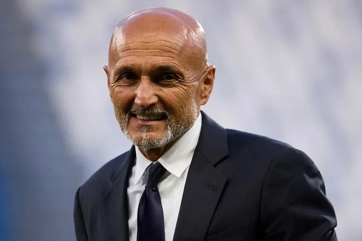 Coach smiling while wearing a suit at stadium Coach smiling while wearing a suit at stadium