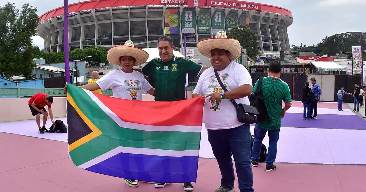 Fans posing with South African flag outside stadium Fans posing with South African flag outside stadium