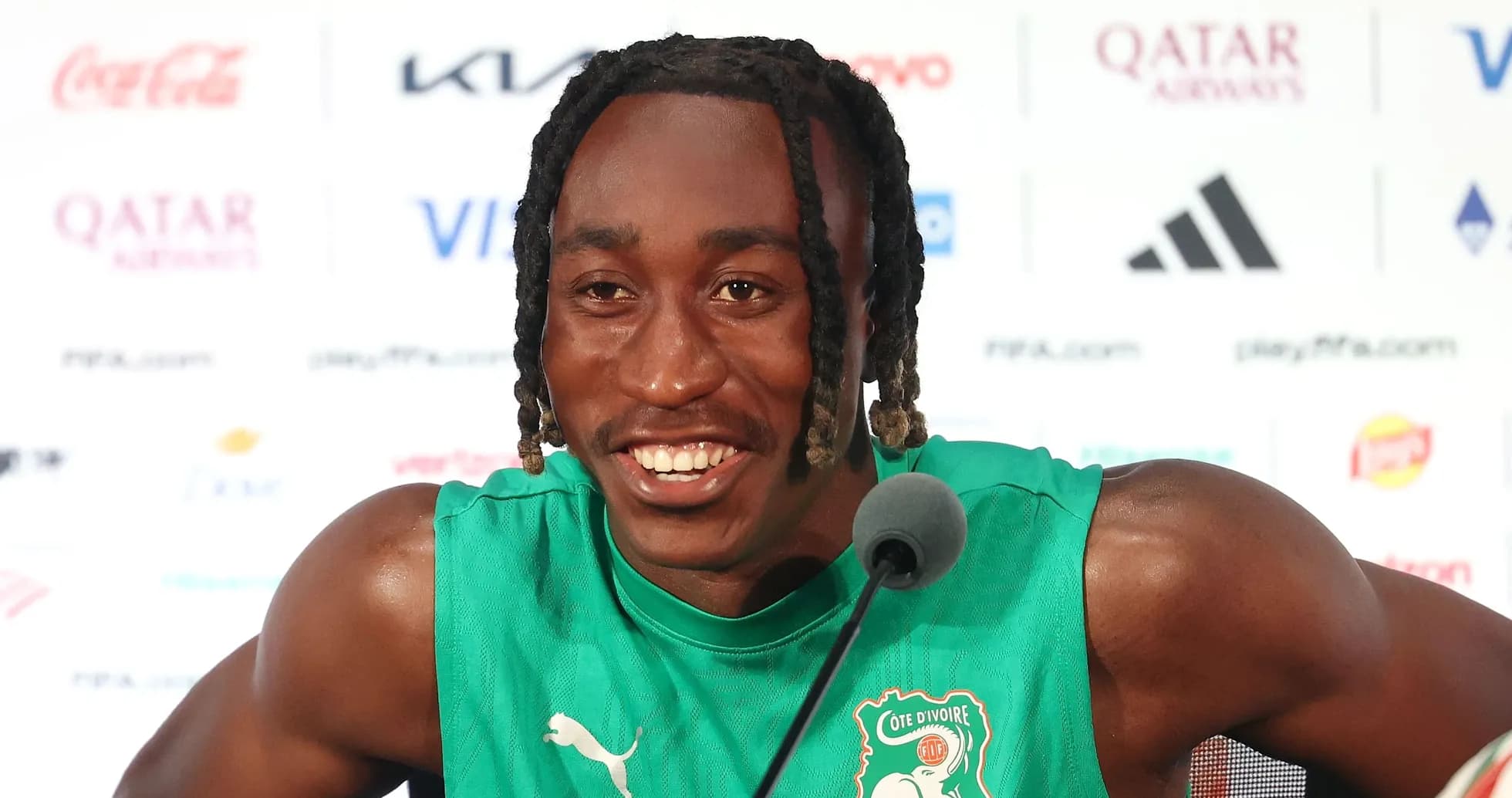 Player speaking at press conference in green jersey Player speaking at press conference in green jersey