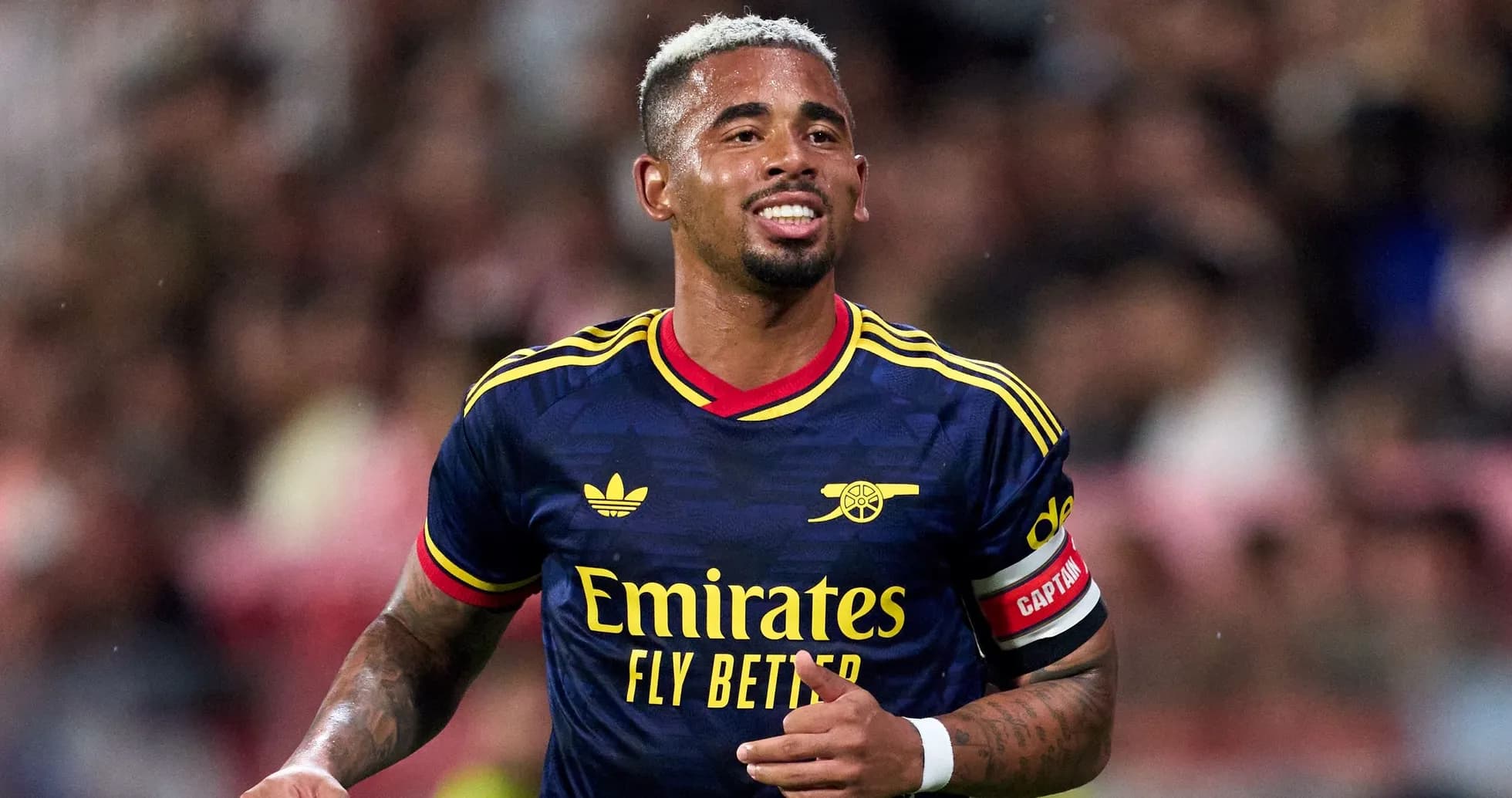 Player in Arsenal kit celebrating on the pitch Player in Arsenal kit celebrating on the pitch