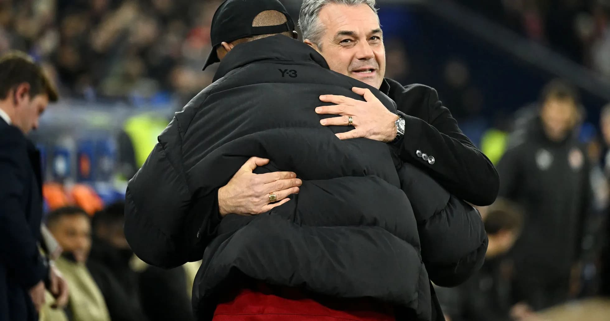 Two coaches embracing on the sidelines Two coaches embracing on the sidelines