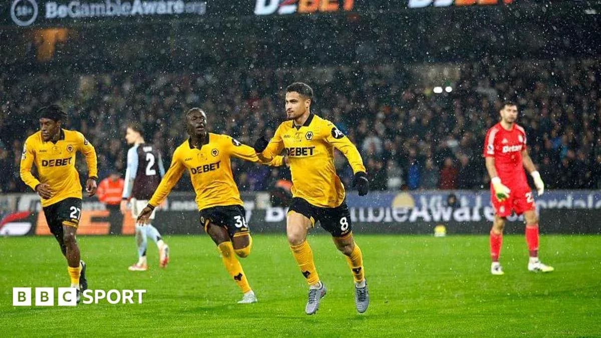 Player celebrating goal with teammates in snowy match Player celebrating goal with teammates in snowy match