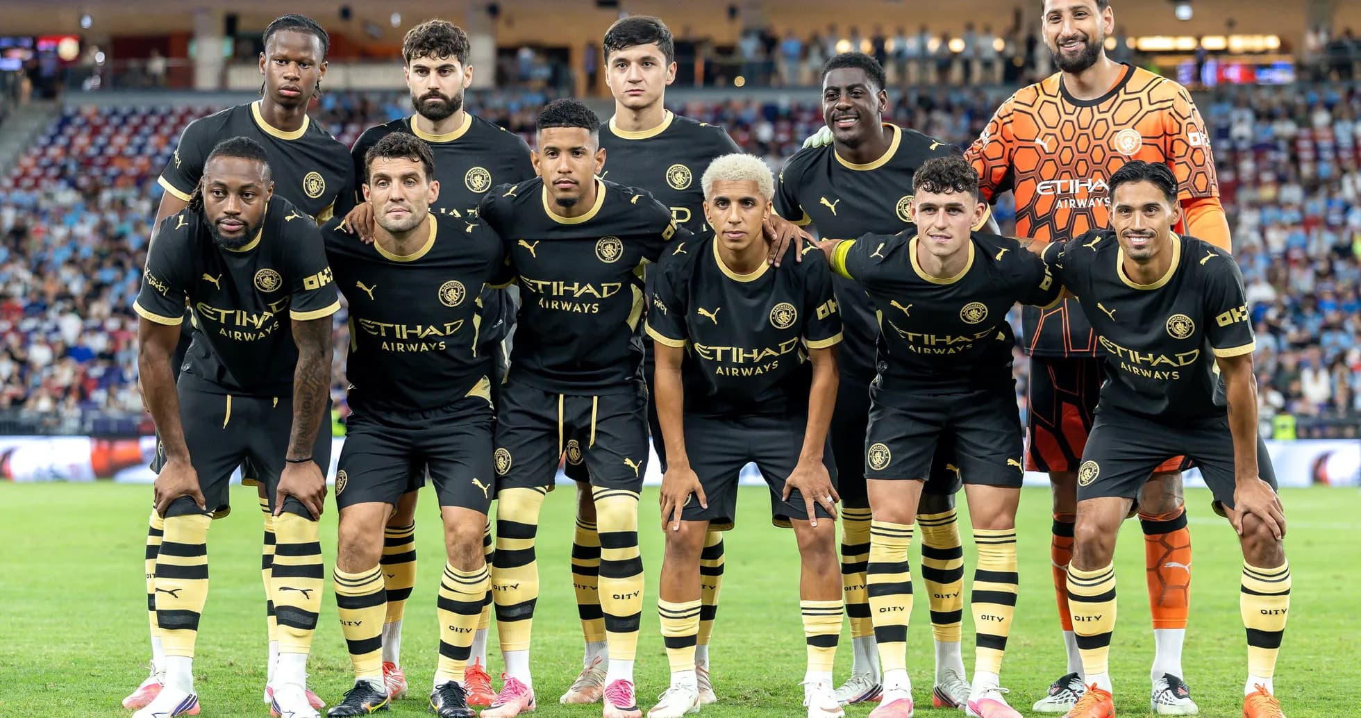 Soccer team posing for group photo in black kit Soccer team posing for group photo in black kit