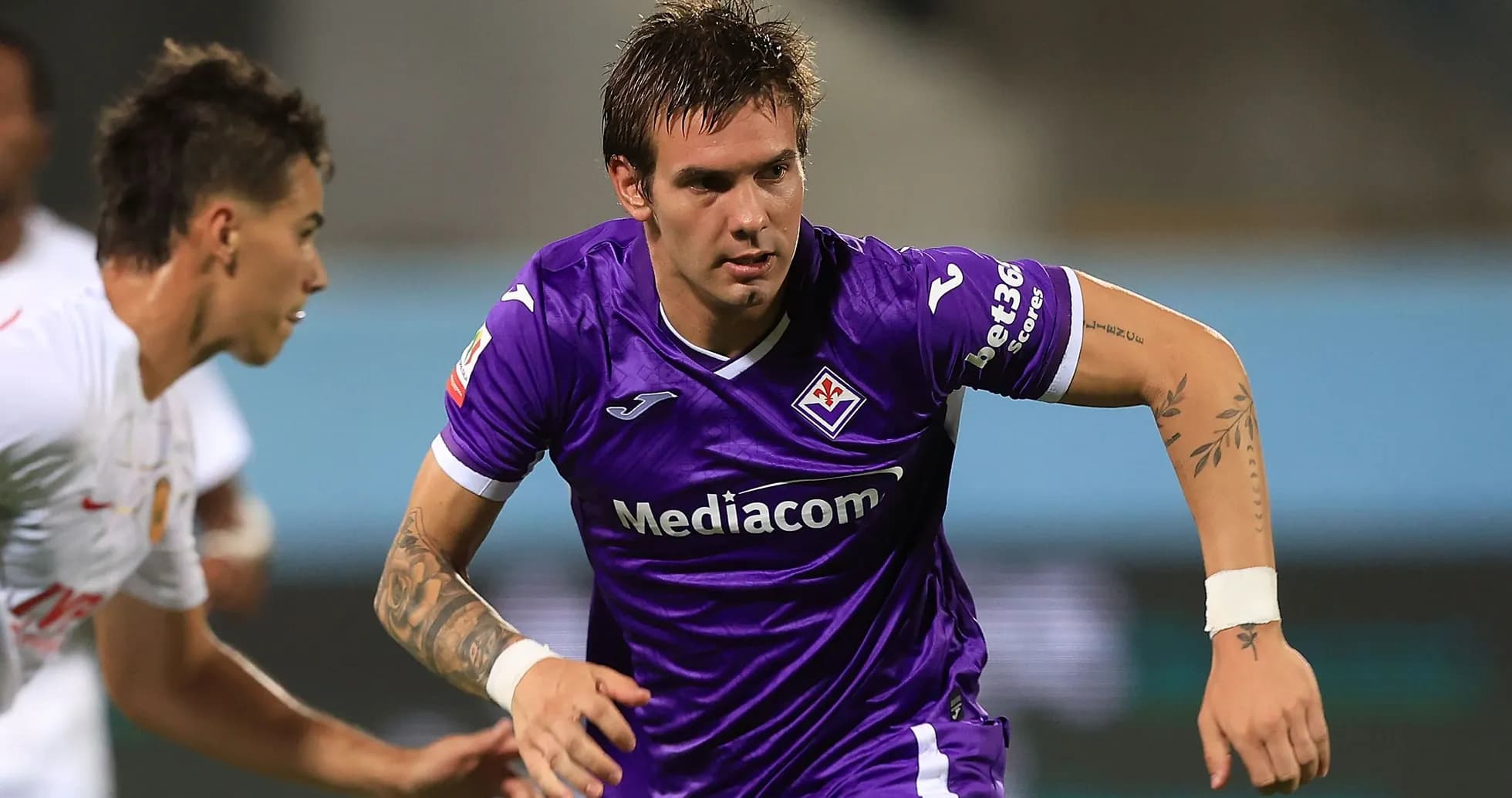 Player in purple jersey running with ball during match Player in purple jersey running with ball during match