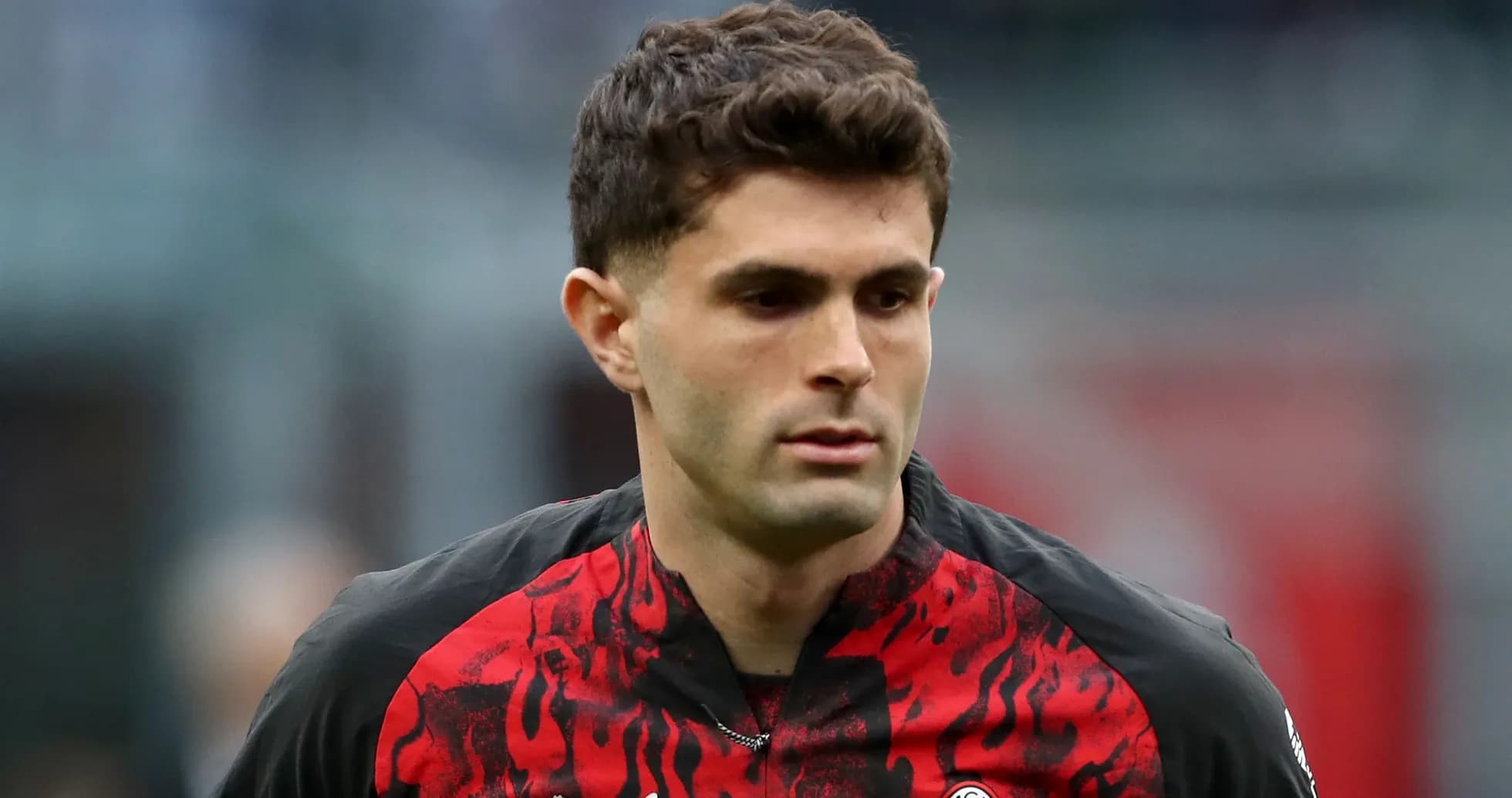 Player in red and black jersey walking on field Player in red and black jersey walking on field