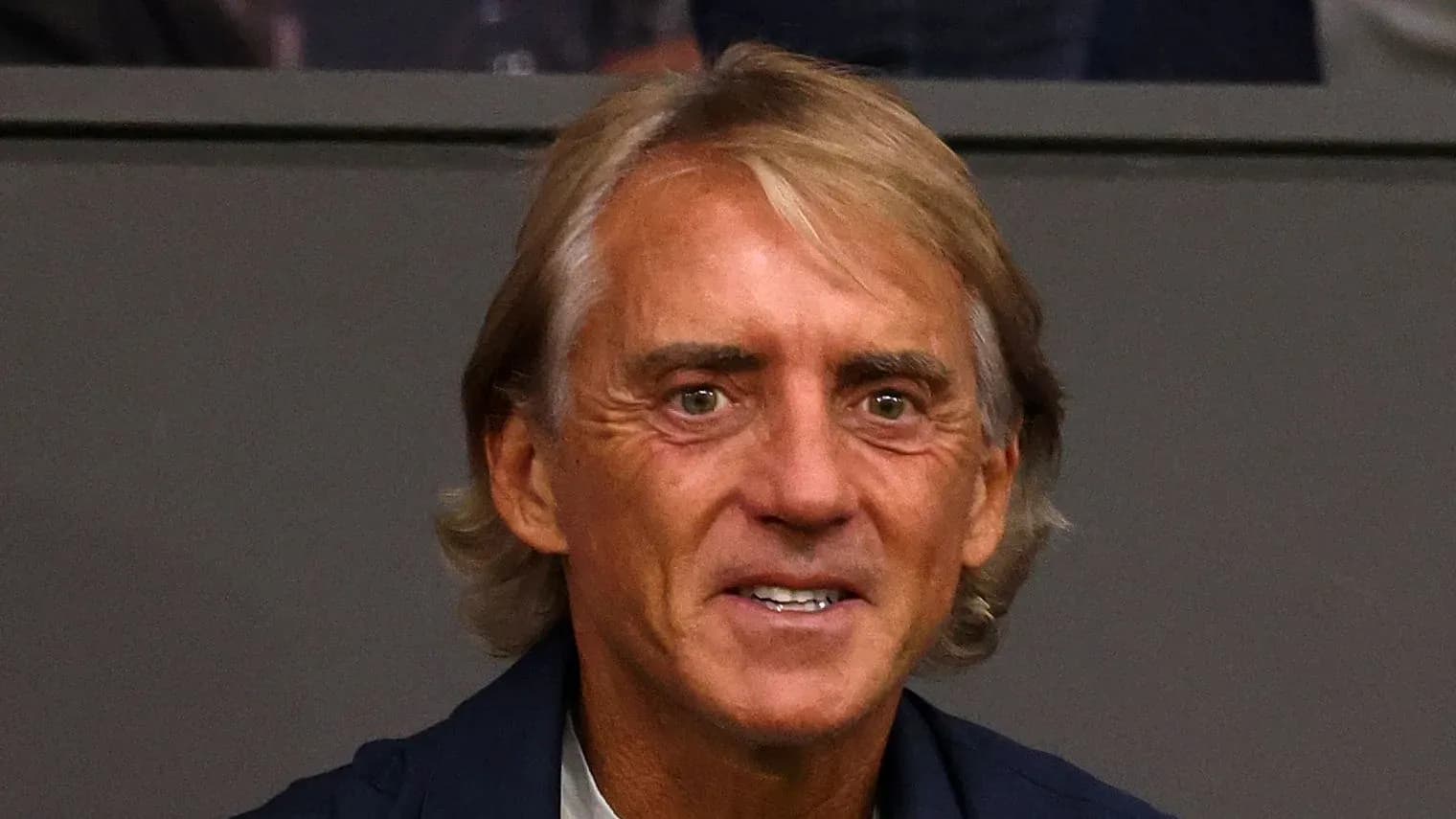 Man with long hair smiling at event Man with long hair smiling at event