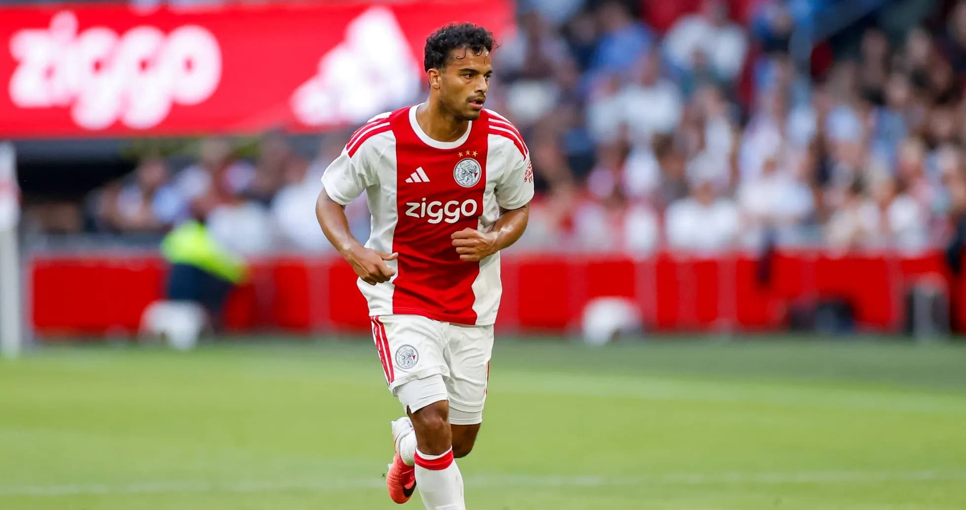 Ajax player running with the ball during match Ajax player running with the ball during match