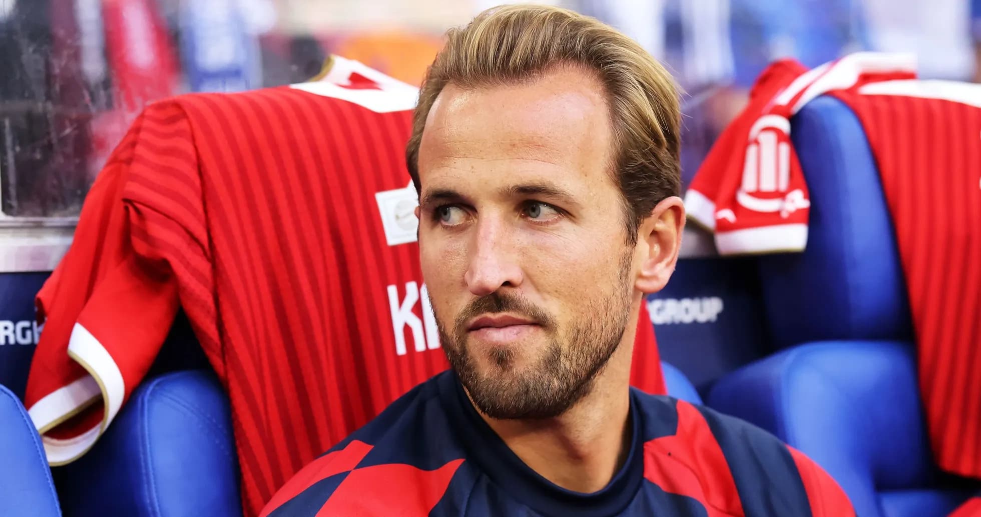 Player seated on bench wearing team jersey Player seated on bench wearing team jersey