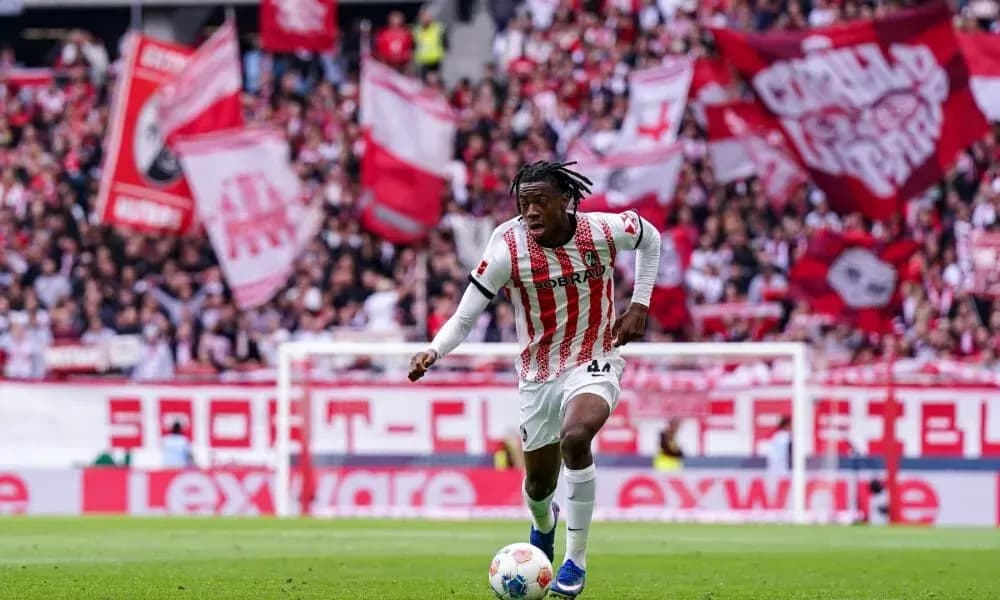 Player dribbling the ball with fans cheering behind Player dribbling the ball with fans cheering behind