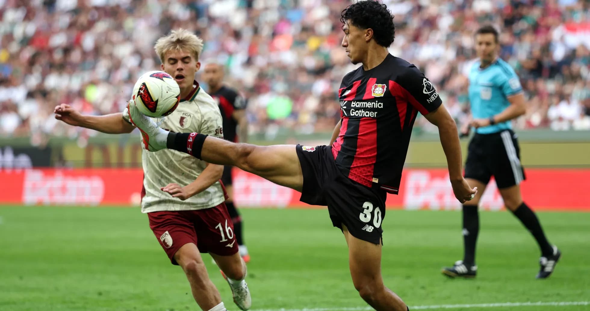 Player kicking ball while opponent approaches during match Player kicking ball while opponent approaches during match