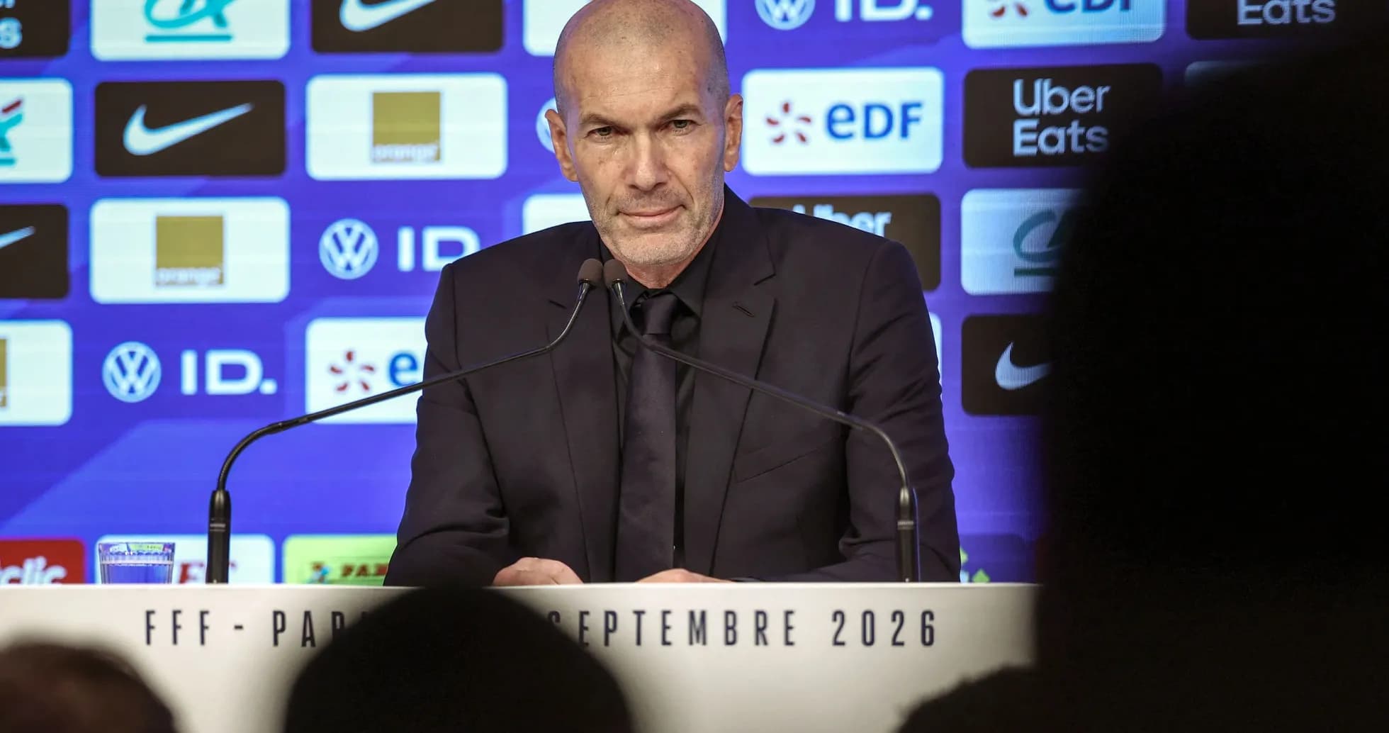 Manager speaking at press conference with logos behind Manager speaking at press conference with logos behind