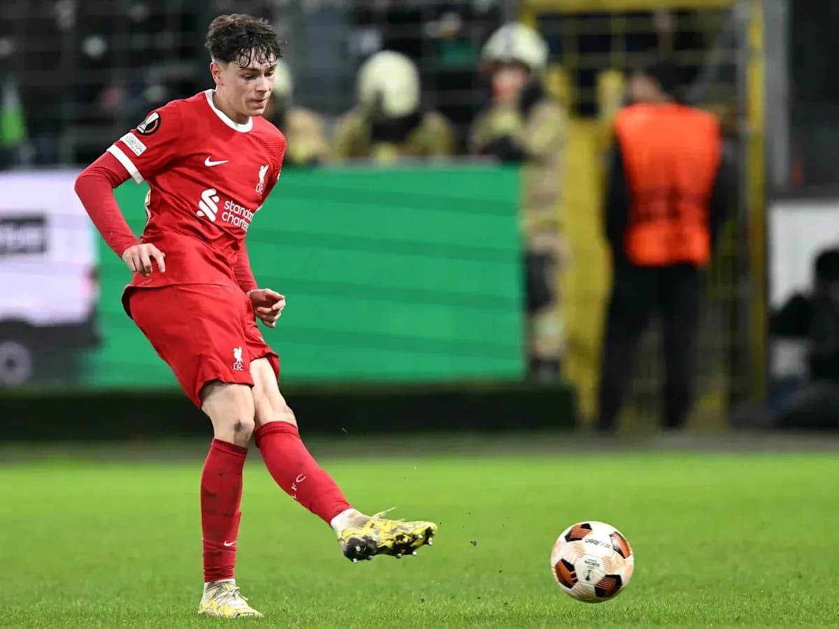 Player in red kit kicking a soccer ball Player in red kit kicking a soccer ball