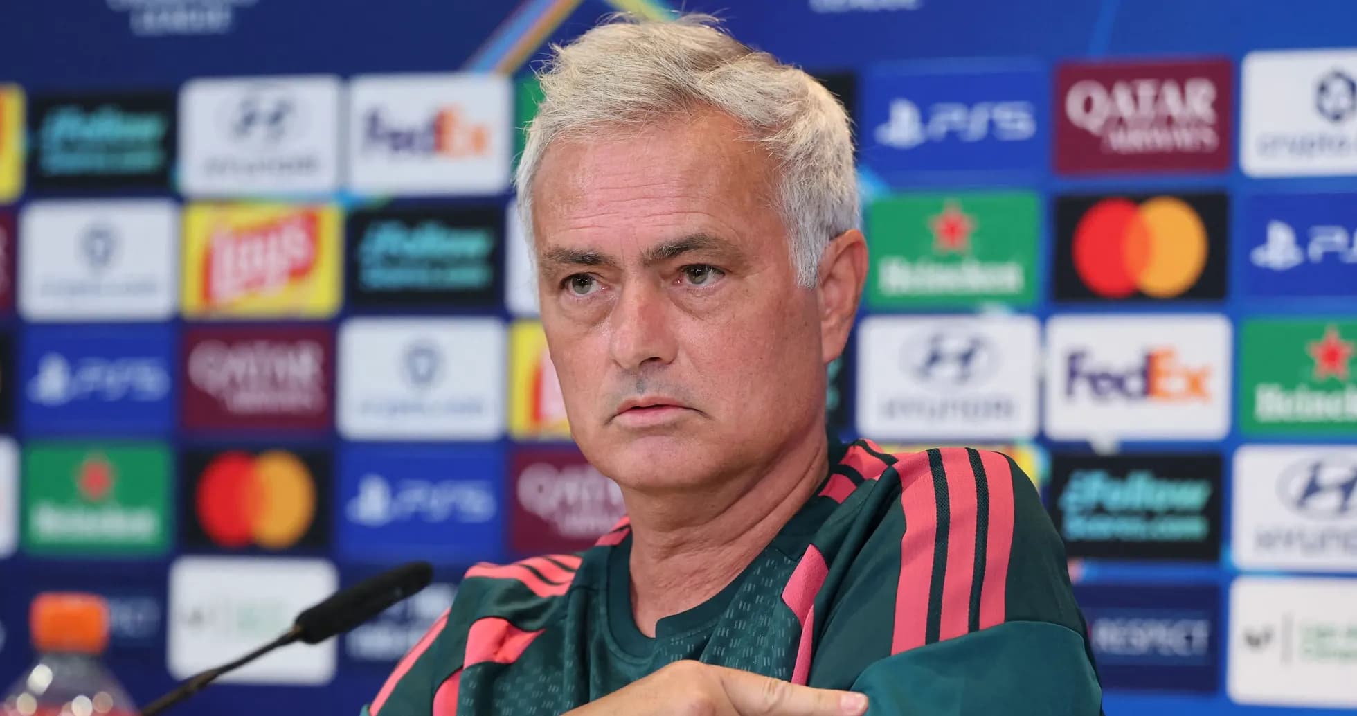 Manager speaking at press conference with logos behind Manager speaking at press conference with logos behind