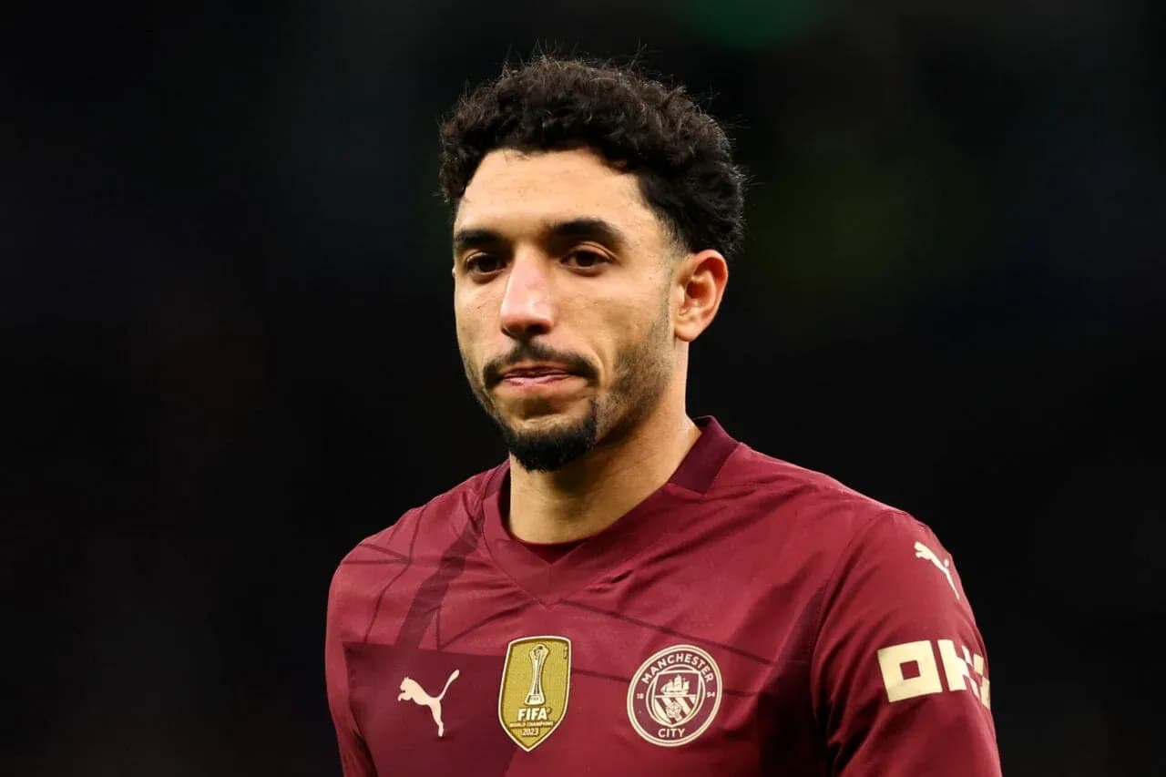 Player in maroon jersey walking on field Player in maroon jersey walking on field