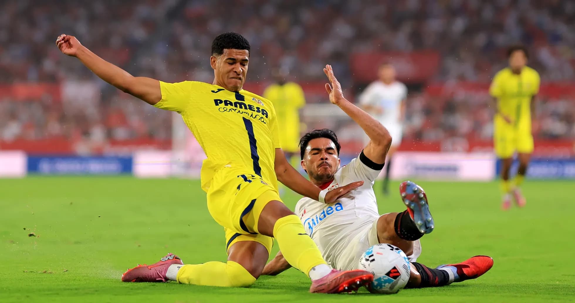 Villarreal player tackling Sevilla player during match Villarreal player tackling Sevilla player during match