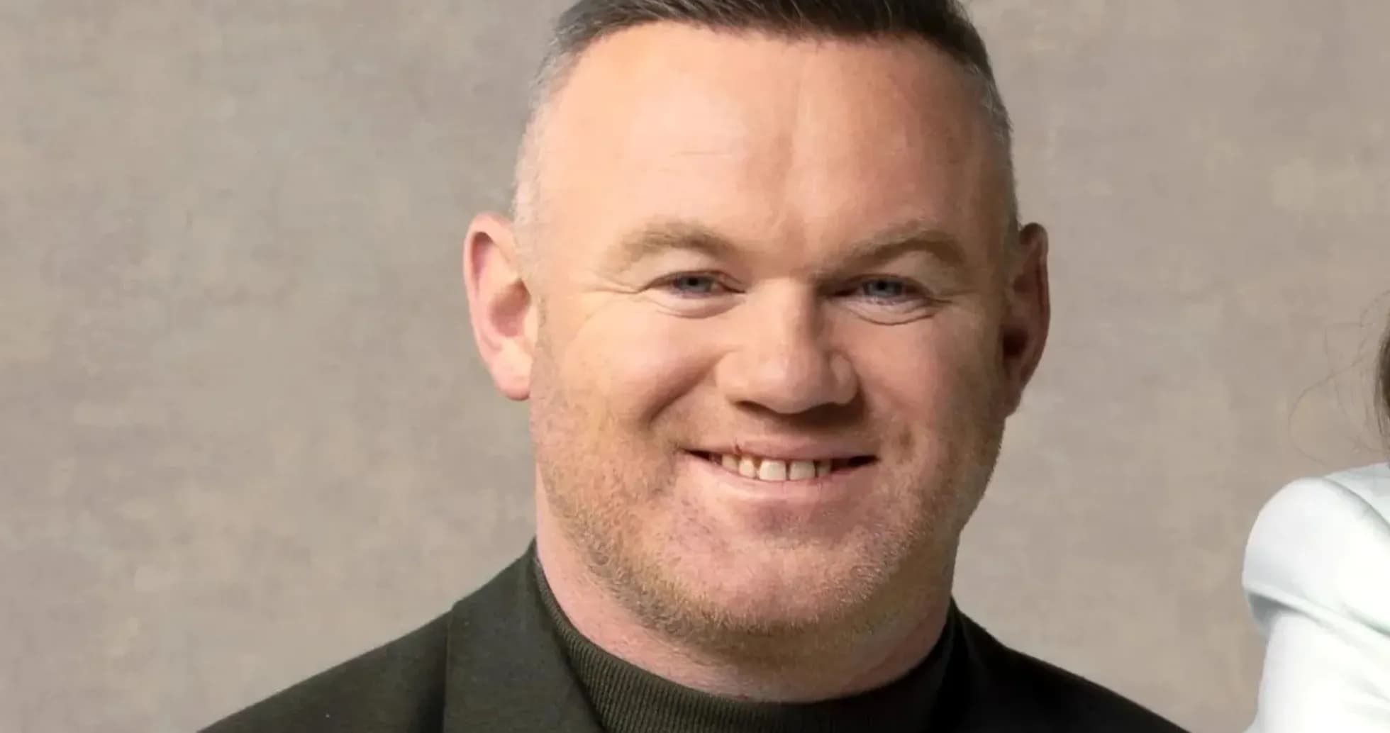 Man smiling in a dark jacket against neutral background Man smiling in a dark jacket against neutral background