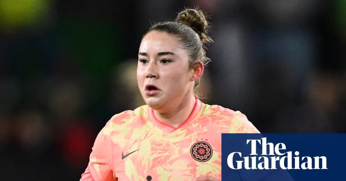 Goalkeeper in pink uniform during match action Goalkeeper in pink uniform during match action