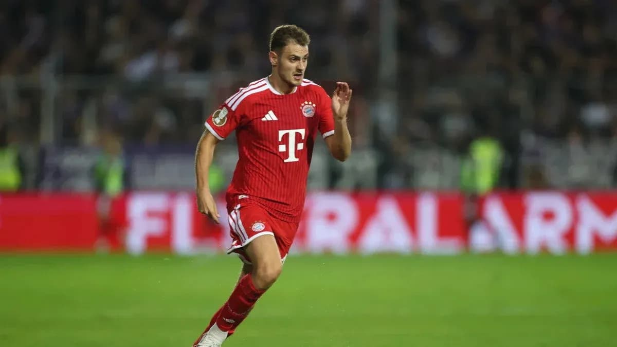 Player in red Bayern Munich kit running on field Player in red Bayern Munich kit running on field