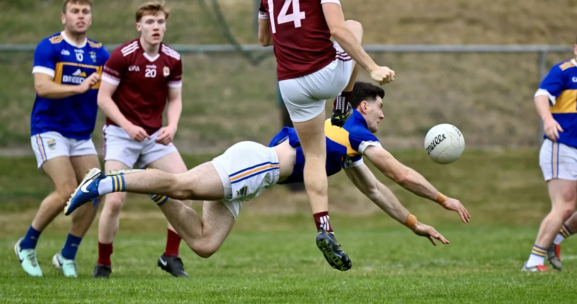 Player diving for the ball during a Gaelic football match Player diving for the ball during a Gaelic football match