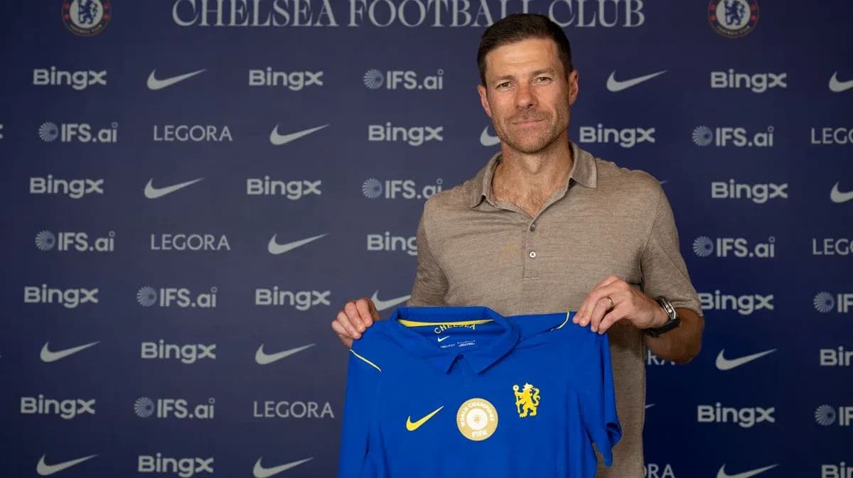 New coach holding Chelsea jersey at press event New coach holding Chelsea jersey at press event
