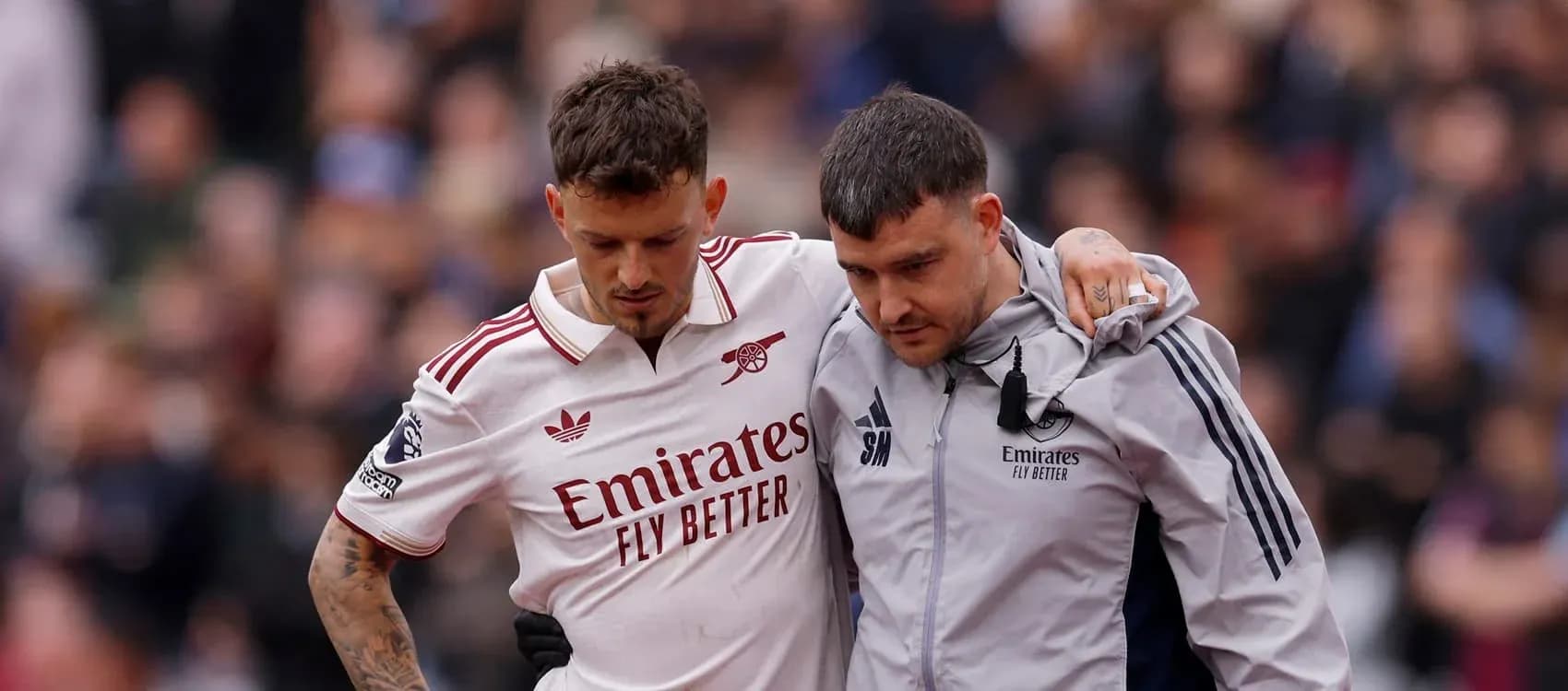 Player assisted off the field by staff member Player assisted off the field by staff member