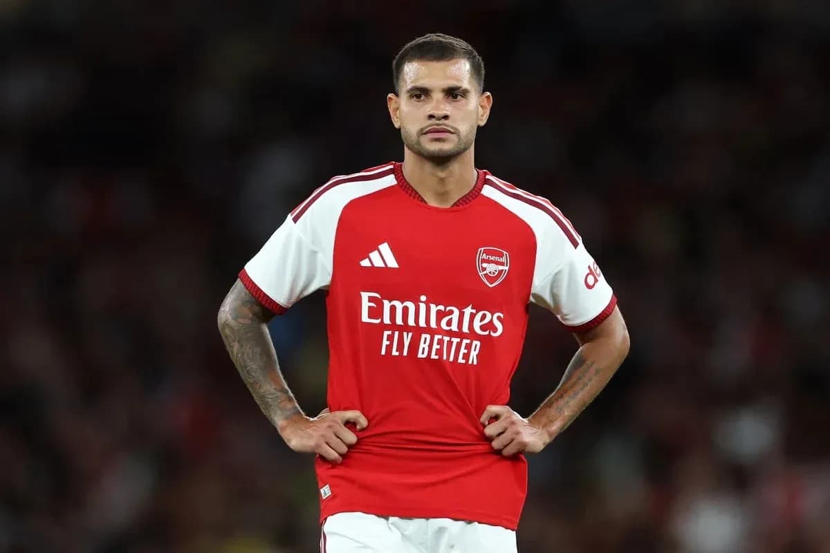 Player in Arsenal jersey standing on the field Player in Arsenal jersey standing on the field