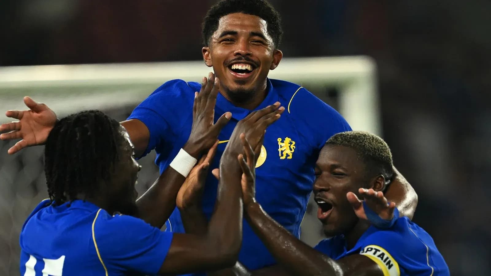 Players celebrating a goal in blue jerseys Players celebrating a goal in blue jerseys