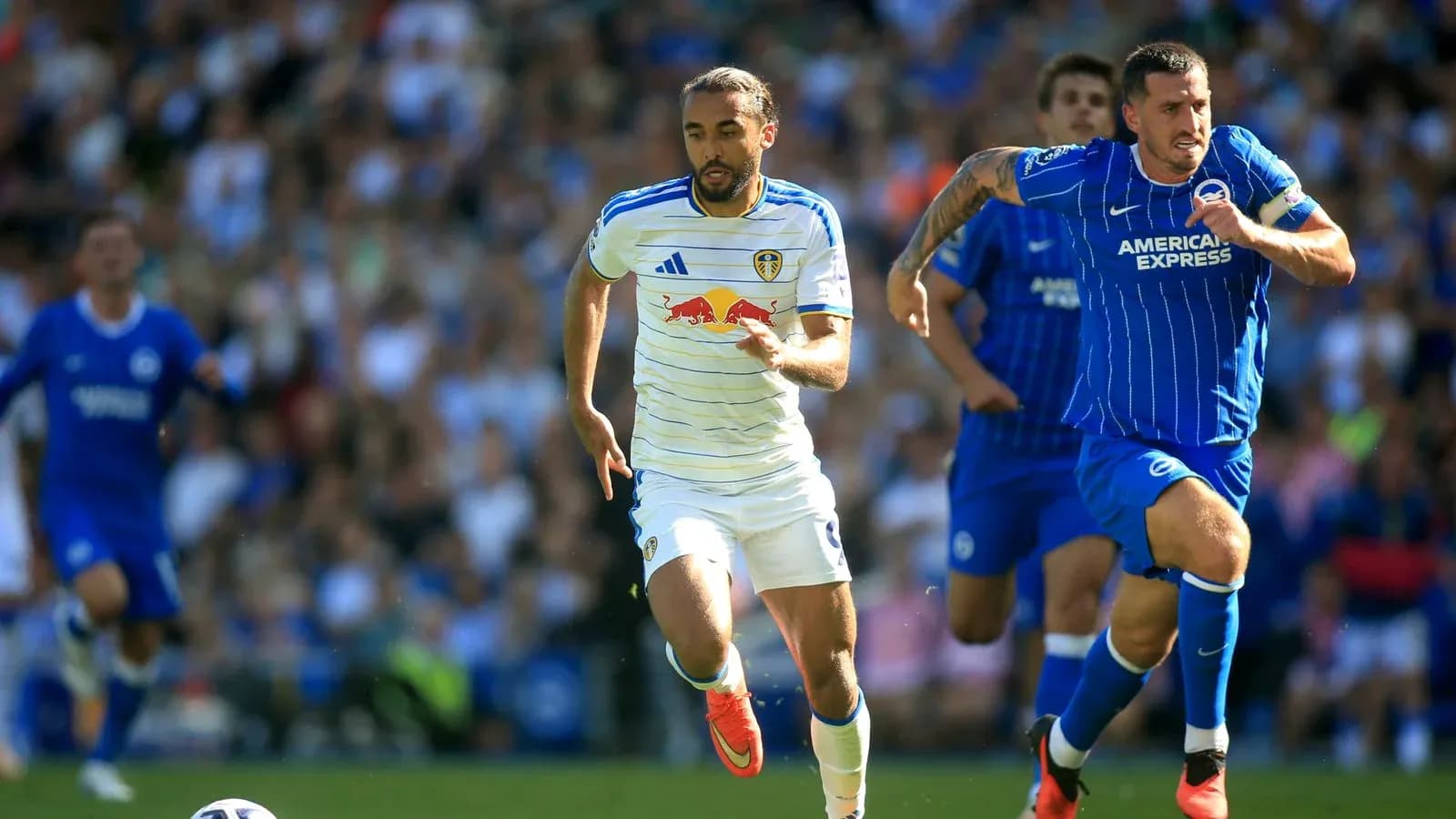 Leeds player sprinting with Brighton player in pursuit Leeds player sprinting with Brighton player in pursuit