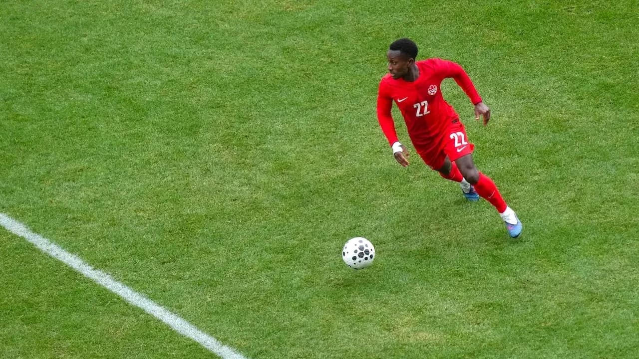 Canadian player running with the ball on field Canadian player running with the ball on field