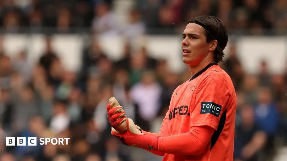 Goalkeeper in orange kit during a match Goalkeeper in orange kit during a match