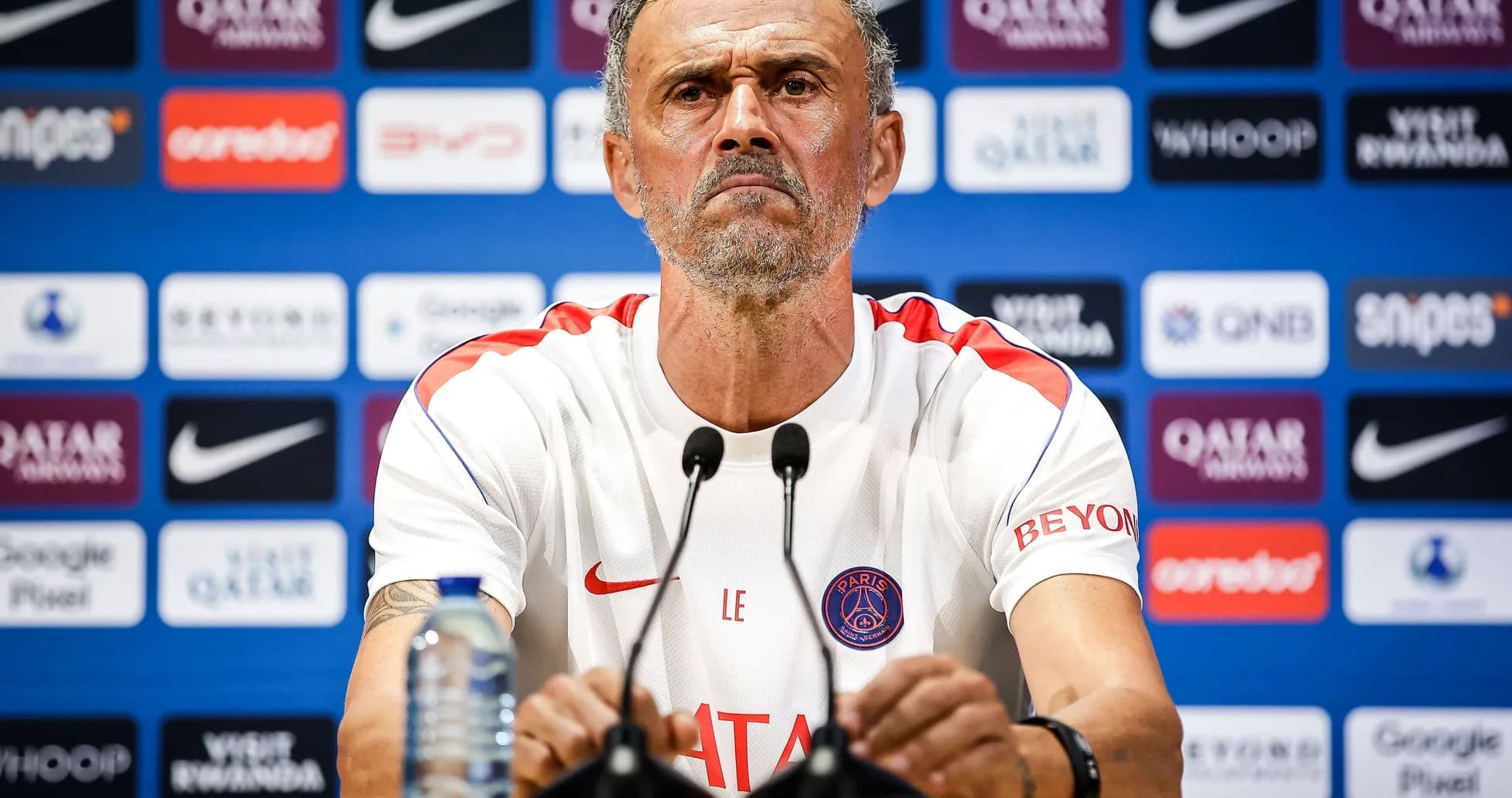 Manager at press conference with PSG branding Manager at press conference with PSG branding