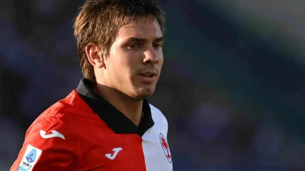 Player in red and white jersey on the field Player in red and white jersey on the field