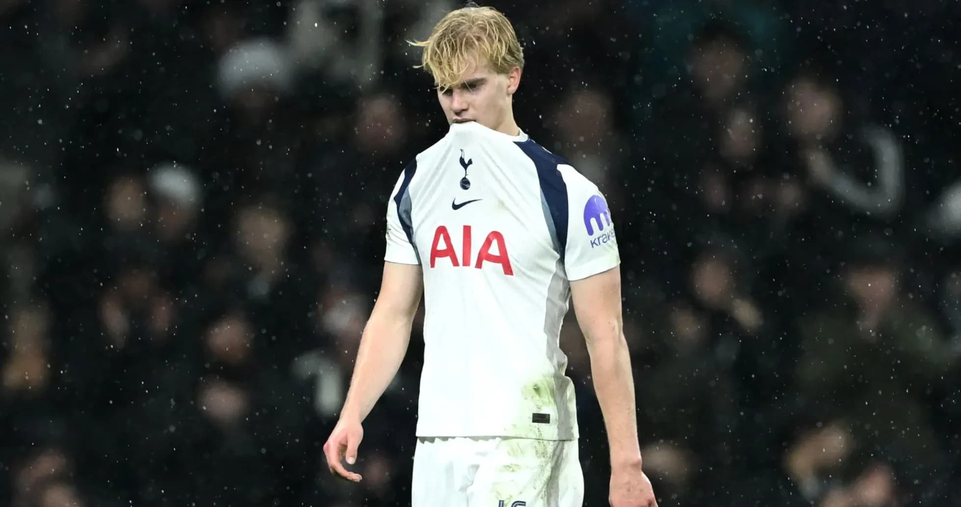 Player looking down, wearing Tottenham kit in rain Player looking down, wearing Tottenham kit in rain