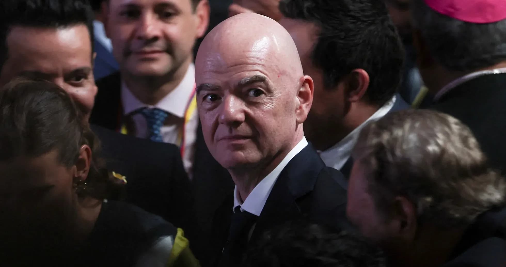 Man in suit surrounded by a crowd at event Man in suit surrounded by a crowd at event