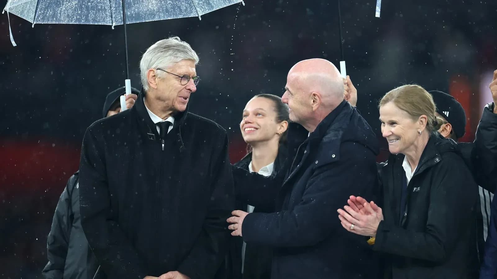 Group of officials under an umbrella at event Group of officials under an umbrella at event