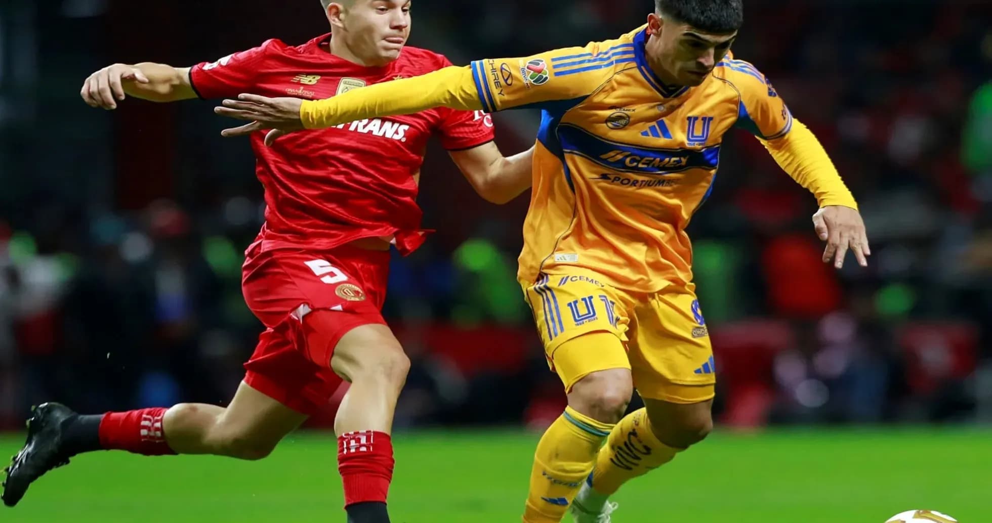 Toluca player challenges Tigres UANL player for the ball Toluca player challenges Tigres UANL player for the ball