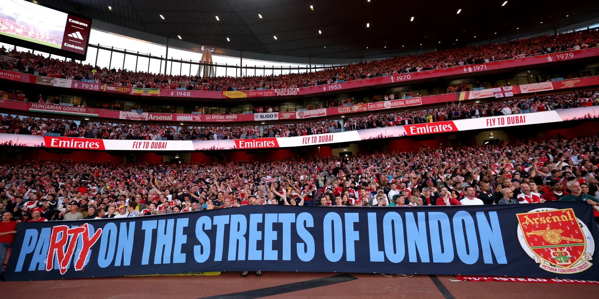 Arsenal fans holding a banner in stadium Arsenal fans holding a banner in stadium