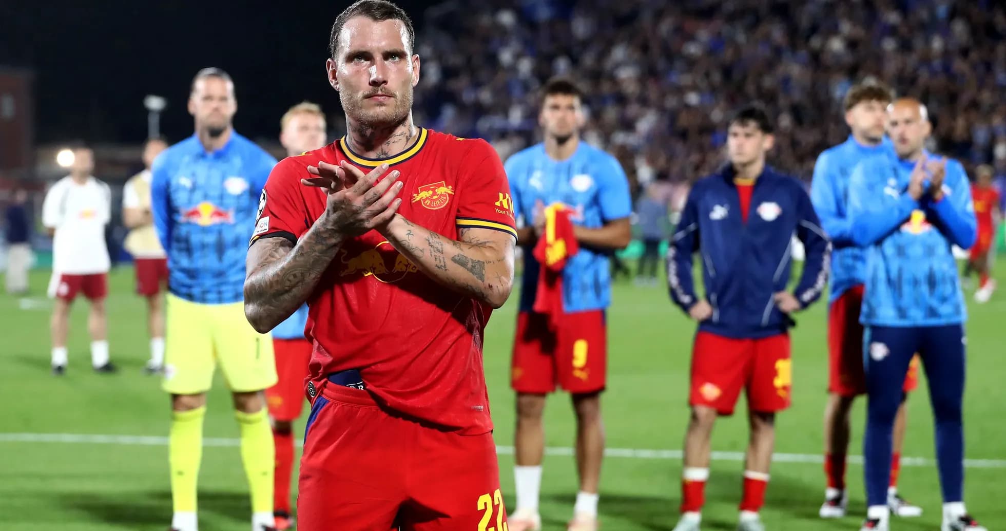 Player applauding with teammates in background Player applauding with teammates in background