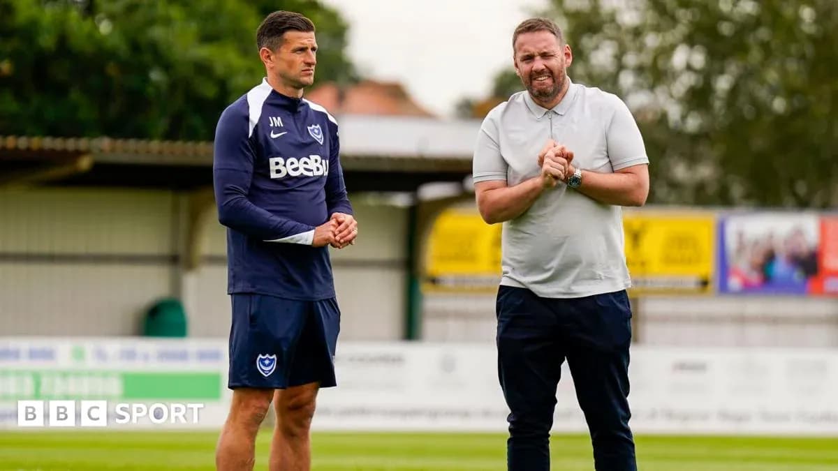 Two coaches discussing strategy on training pitch Two coaches discussing strategy on training pitch