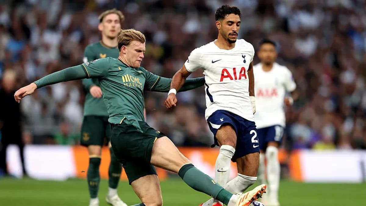 Player from Tottenham challenged by opponent during match Player from Tottenham challenged by opponent during match