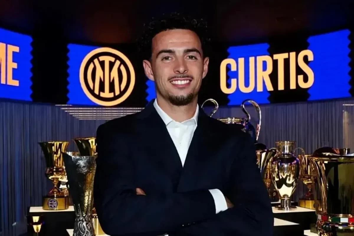 Man in suit smiling with trophies in background Man in suit smiling with trophies in background